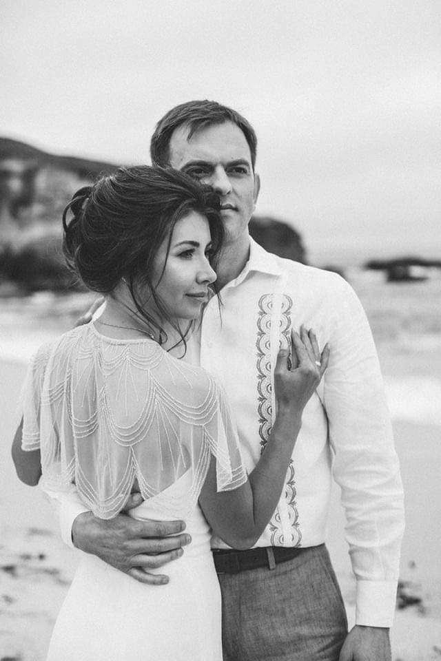 A black and white photo of a couple on the beach